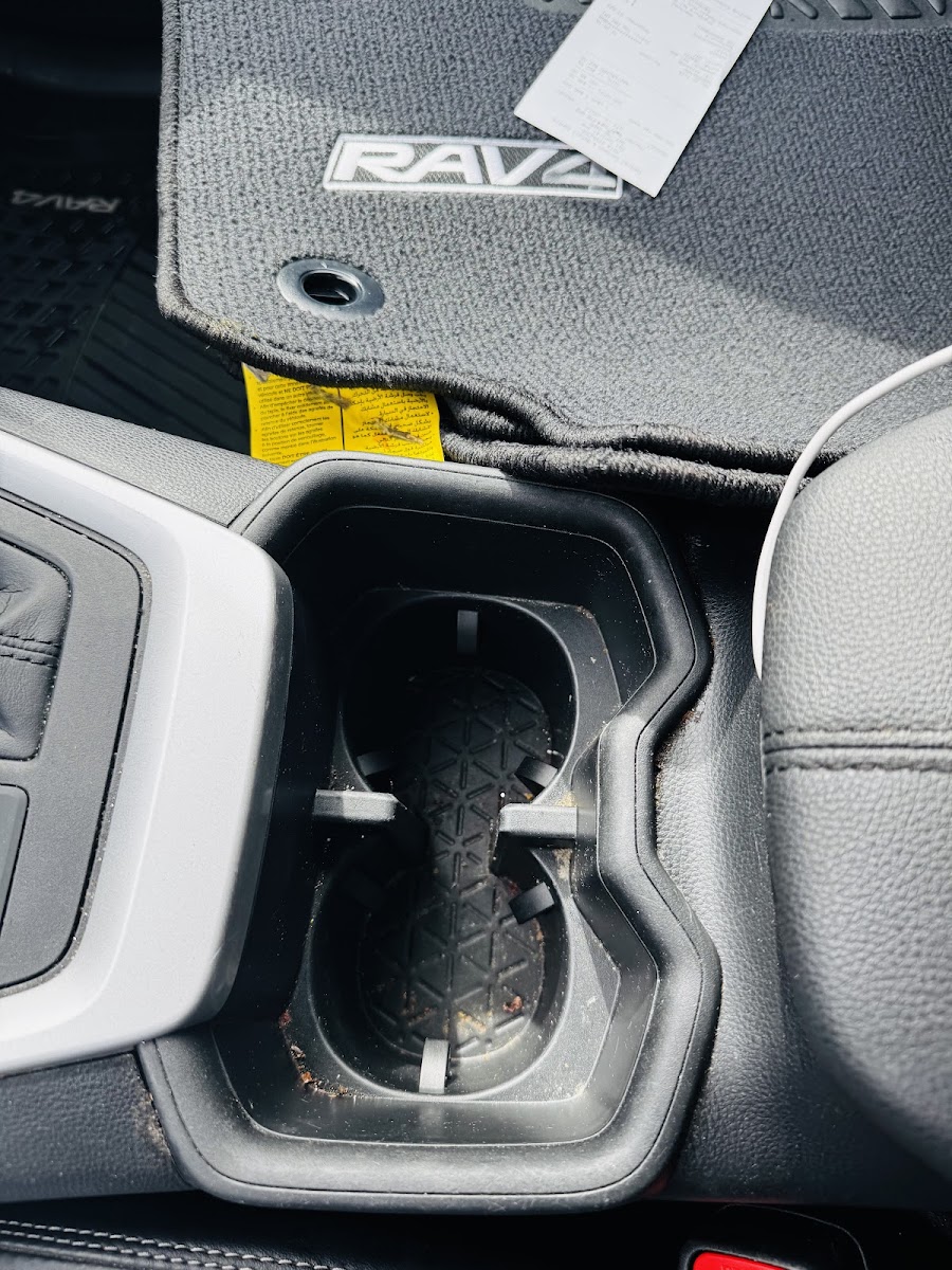 Center console cup holders before vacuum and wipe-down.